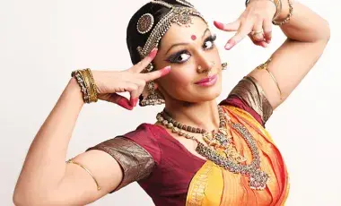 A woman is dancing dresses in a custom from a Bollywood Indian movie