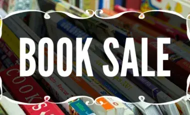 Words Book Sale in a stylish frame on the background of books of various colors