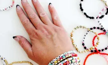 A wrist full of beaded friendship bracelets.