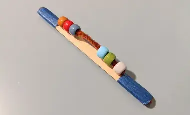 fidget stick made out craft stick, chenille stick, and beads