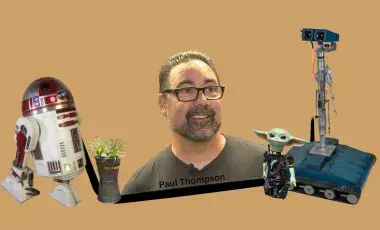 Paul Thompson surrounded by some of his robotic creations.