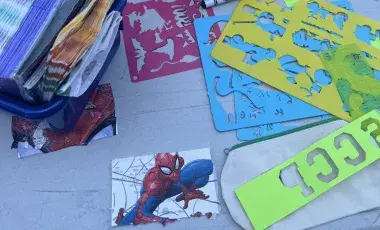 craft table with catalog cards, markers, decorative napkins, and stencils