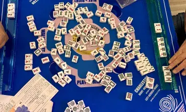 Mahjong tiles on a game board table.