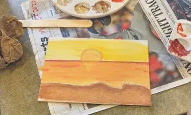 A painting laying on top of a newspaper.