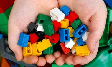 Child's hands holding Lego bricks. 