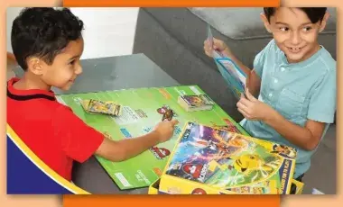 Two children playing Pokemon Battle Academy