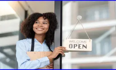 Women holding an open sign for her business