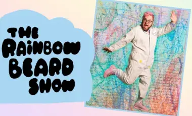 Ricky Rainbow Beard, with pink hair and a jumpsuit with the test "The Rainbow Beard Show."