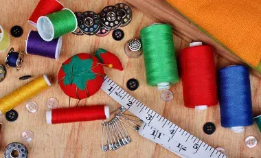 sewing material thread various colors measuring tape buttons bobbin and safety pins