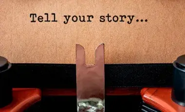 typewriter with a page that reads tell your story...