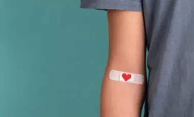Image of an arm with a heart-themed band-aid affixed 