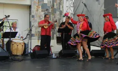 Four men playing instruments while two women and two men dance