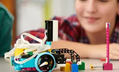 LEGO robot in foreground with a youth maker in the background.