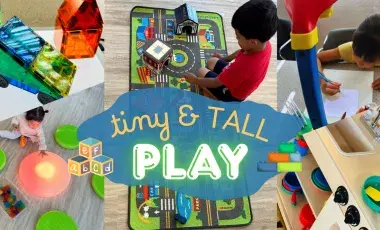 "Tiny & Tall Play" in front of a photo of children playing with a toy town, tracing projector, light and magnatiles stations, and a pretend kitchen.