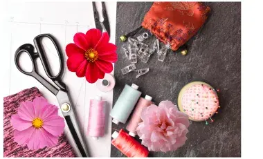 sewing supplies and flowers scattered on a table