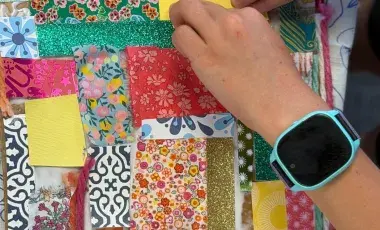 Hands work on an upcycled craft project