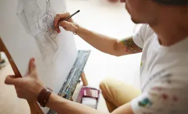 A man sketching with pencil on a pad
