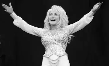 Dolly Parton with her arms up