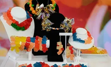 Colorful gummy bear candy jewelry displayed on necklace and bracelet stands.