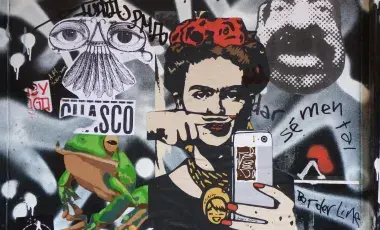 graffiti image of Frida Kahlo holding a cell phone surrounded by a collage of other images and writing