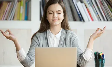 Girl Meditating in front of laptop 