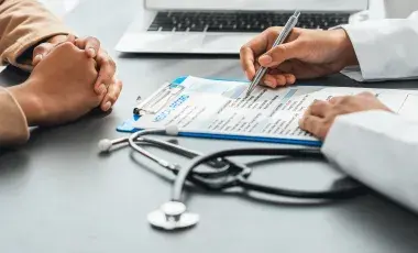 physician's hands filling out form for patient