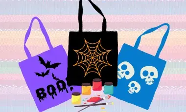 Three tote bags with a halloween theme on a rainbow background with paint supplies. 