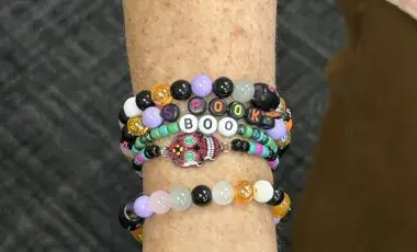 Colorful friendship bracelets on a wrist.