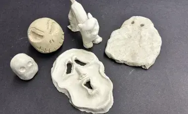 Five different clay creations: two ghosts, a halloween cat, and two scary faces.
