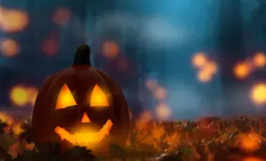 Glowing jack-o-lantern on a leaf covered ground