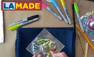 a set of hands coloring in a piece of tin work
