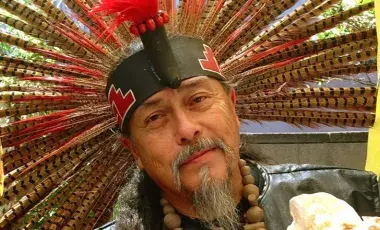 Native American man wearing a headband with feathers