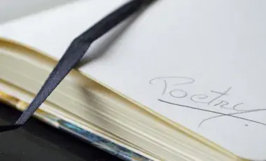 Close-up of a page in a journal with the word poetry written in it.