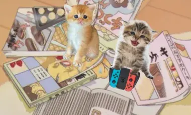 Two kittens on a pile of manga playing Nintendo. 