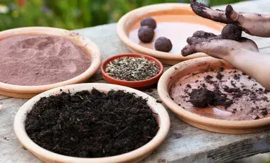 A pair of hands rolling seed bombs.