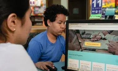 Two teens using computers.