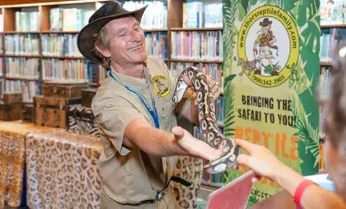 man holding a python snake