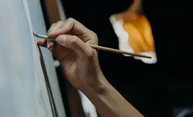 A color photo of a hand painting on canvas