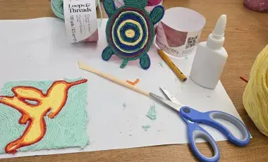 a table with supplies to make craft including scissors, glue, yarn, 