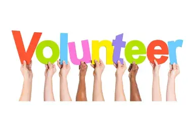 Hands each holding a word that spells out Volunteer.