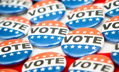 Several red, white, and blue buttons with the word vote written in black.