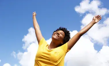 Cheerful young woman with raised hands