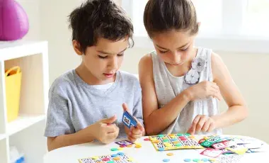 Two young children playing a game of bingo.