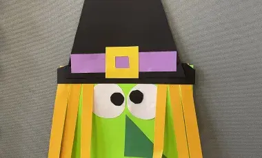 Paper craft of a green witch. 