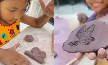 Children playing with clay. A child holds clay with an imprint of a bird in their hand.