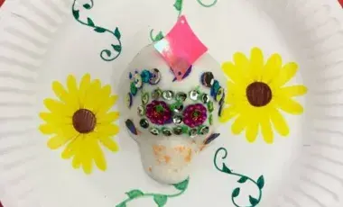 A sugar skull on a decorated plate