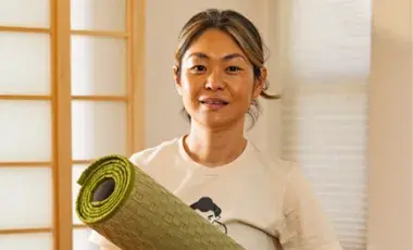 Yoga teacher Sayuri is holding a tatami mat