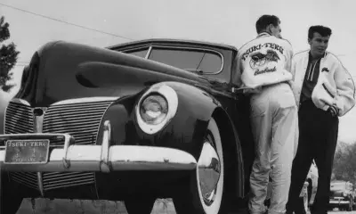 Two people in front of old car, 1954.