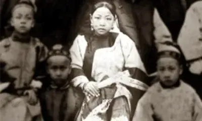 historic photo of young person sitting among children