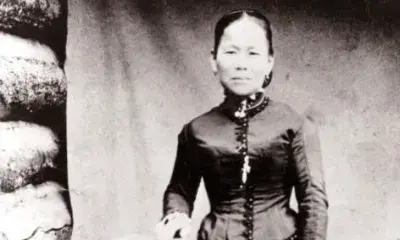Woman wears dress with high neck and long sleeves